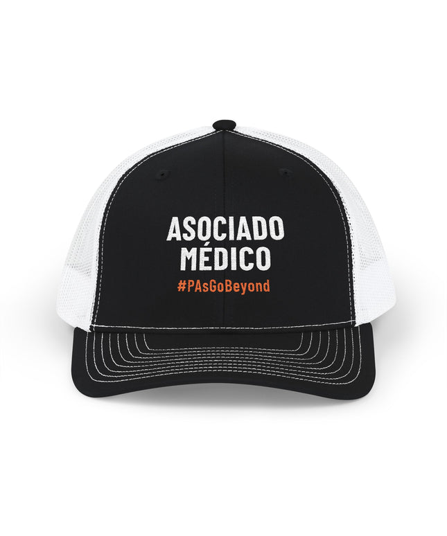 Black and white trucker hat embroidered with "Asociado Médico" in white text and "#PAsGoBeyond" in orange.